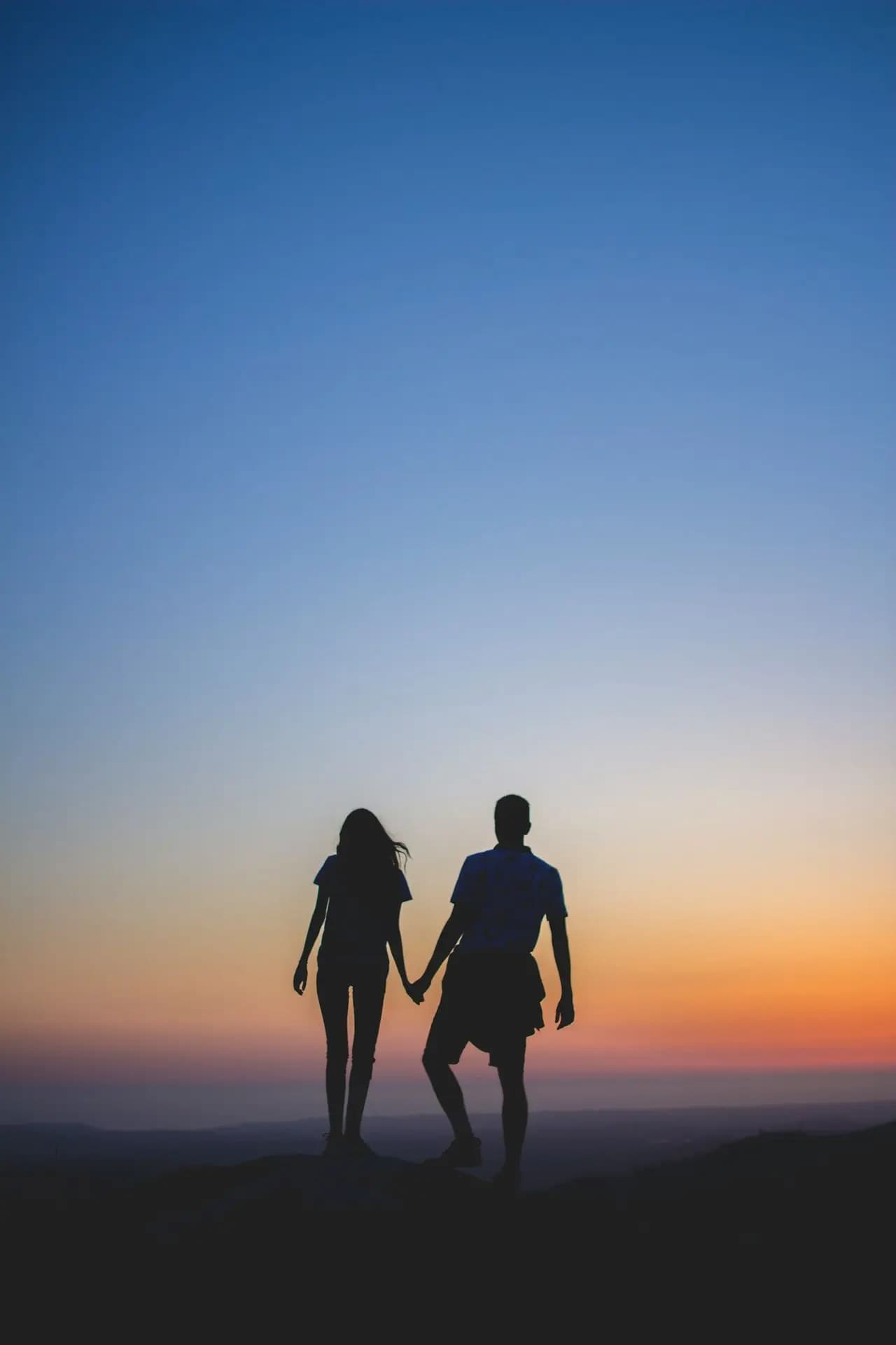 Un couple main dans la main au crépuscule
